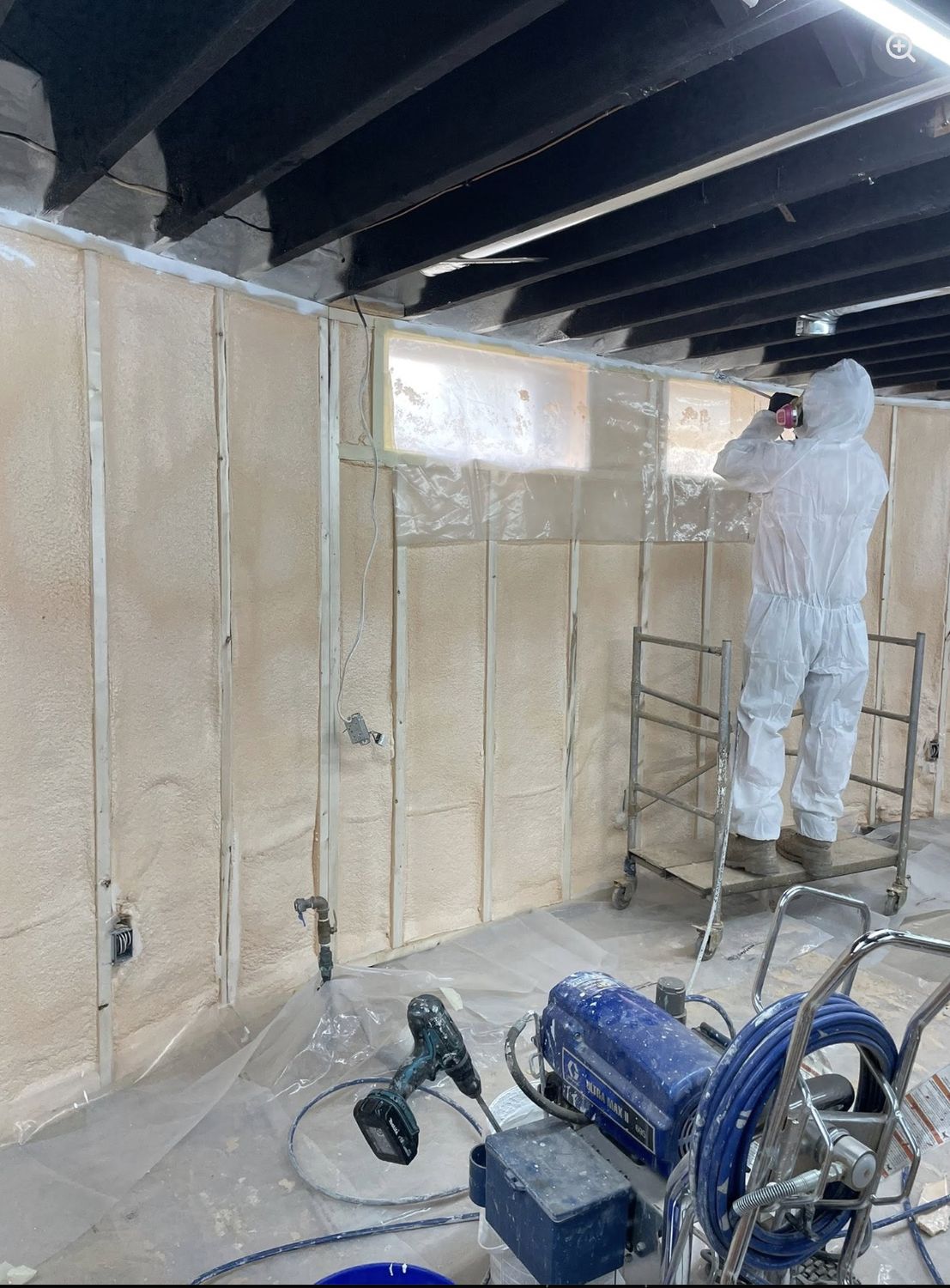 Basement foundation wall having spray foam applied directly to the concrete
