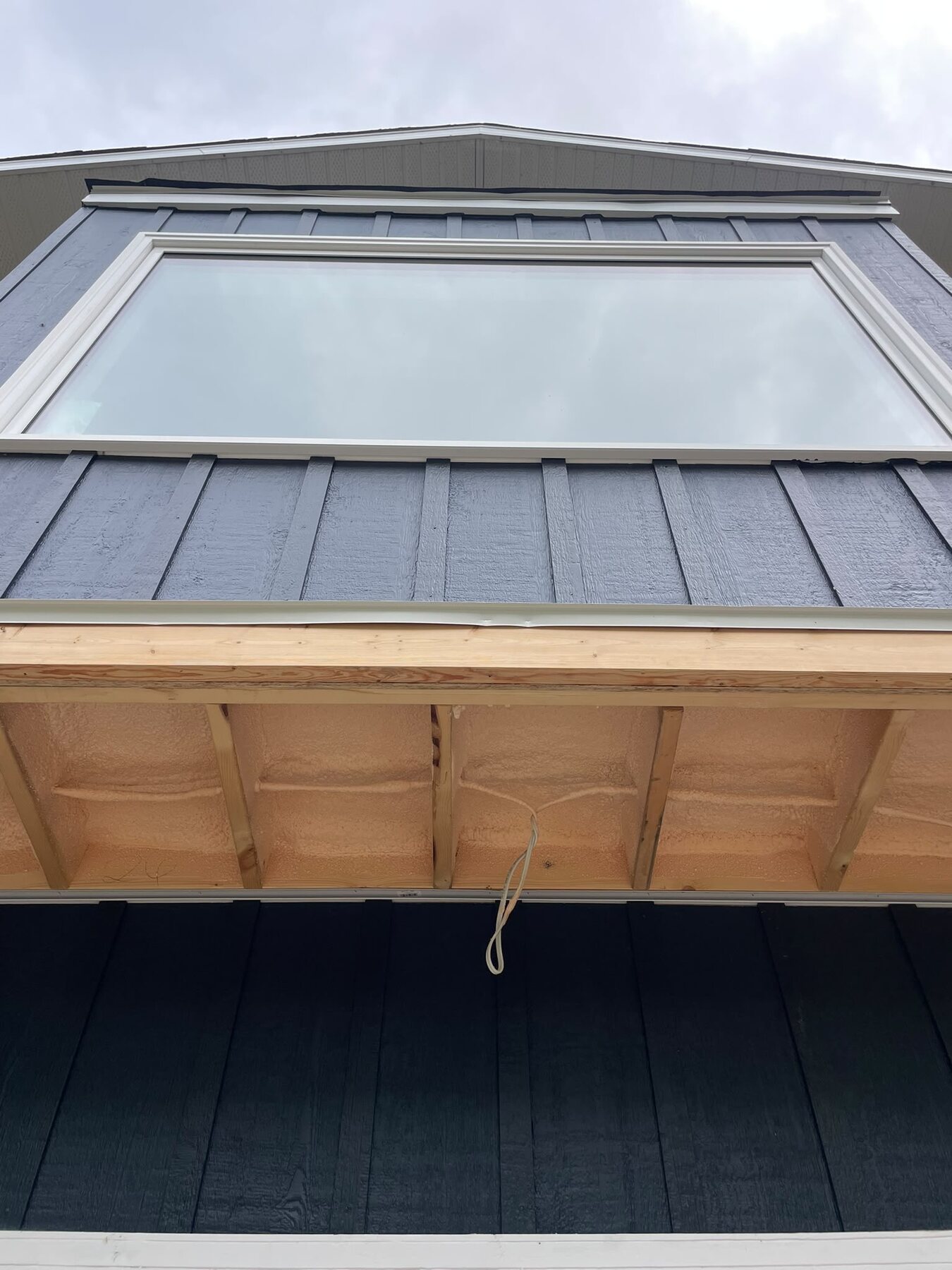 Underside of a cantilevered bay window addition insulated with closed-cell spray foam