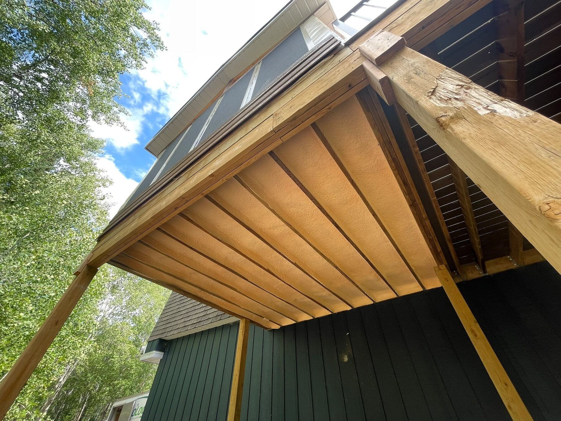 Underside of cantilevered floor joists on a deck addition, fully insulated with closed-cell spray foam