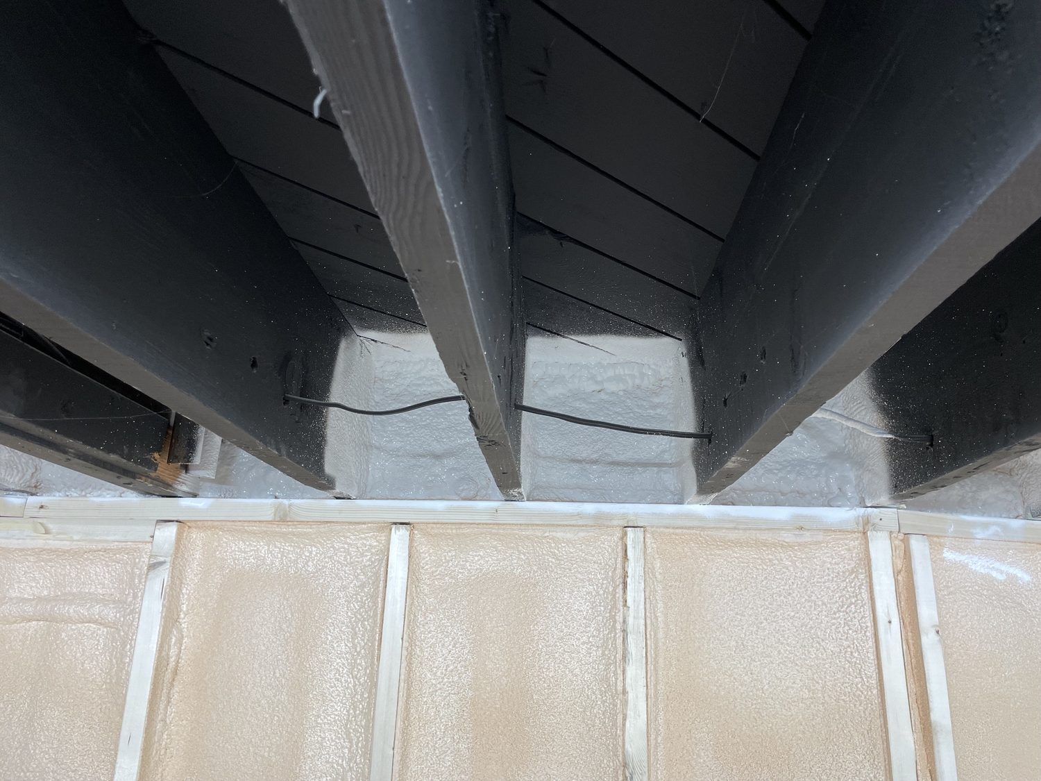 The same rim joist bays after a DC 315 intumescent coating has been sprayed over the cured foam