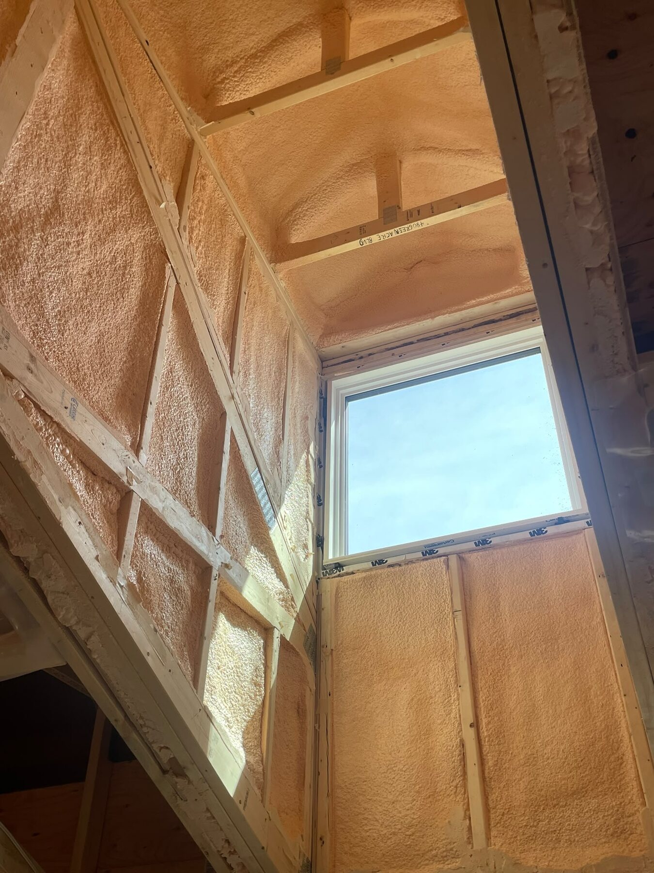 Dormer wall with an installed window, closed-cell foam wrapping the window frame