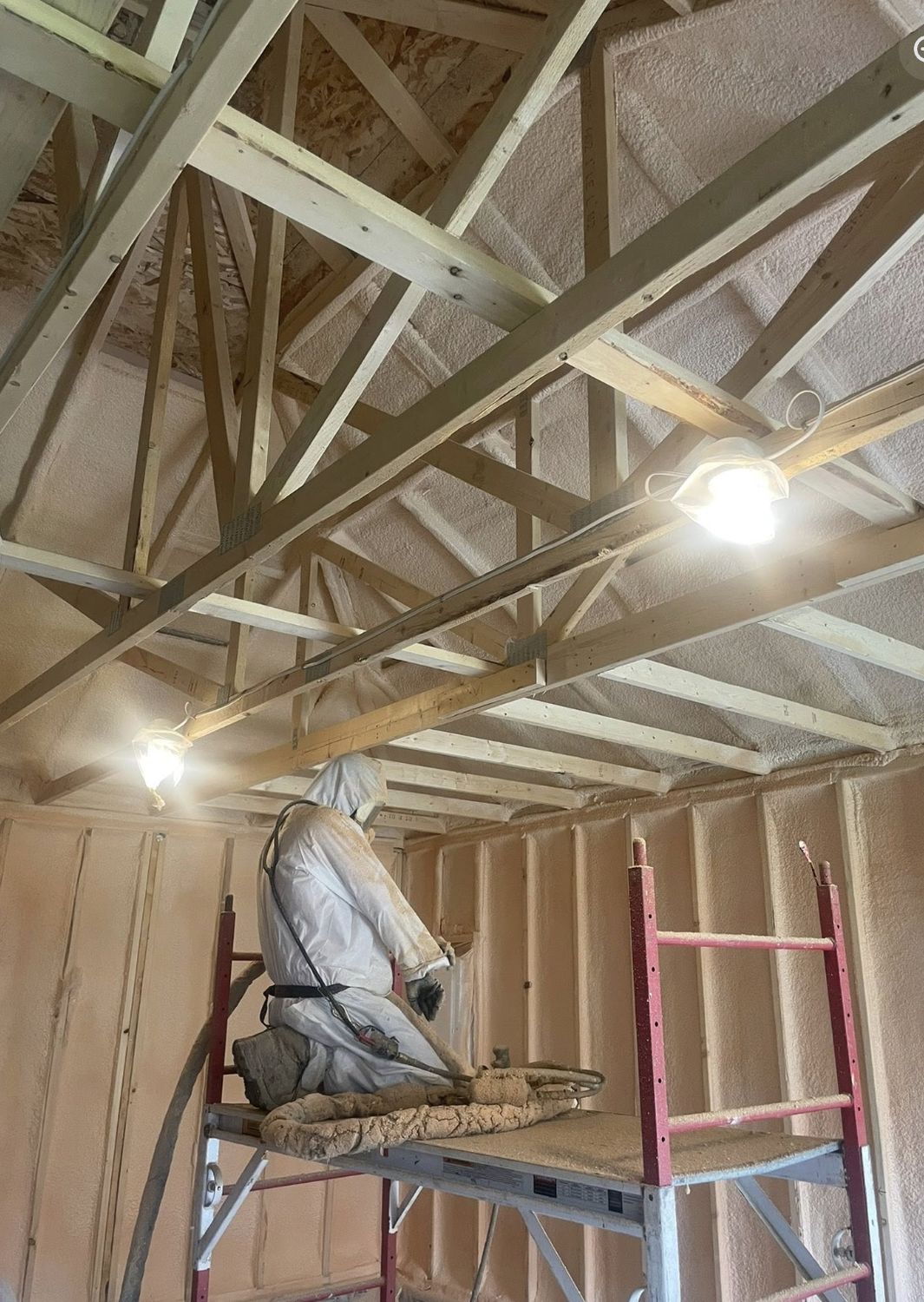 Ecologic spray crew working from scaffolding inside a garage