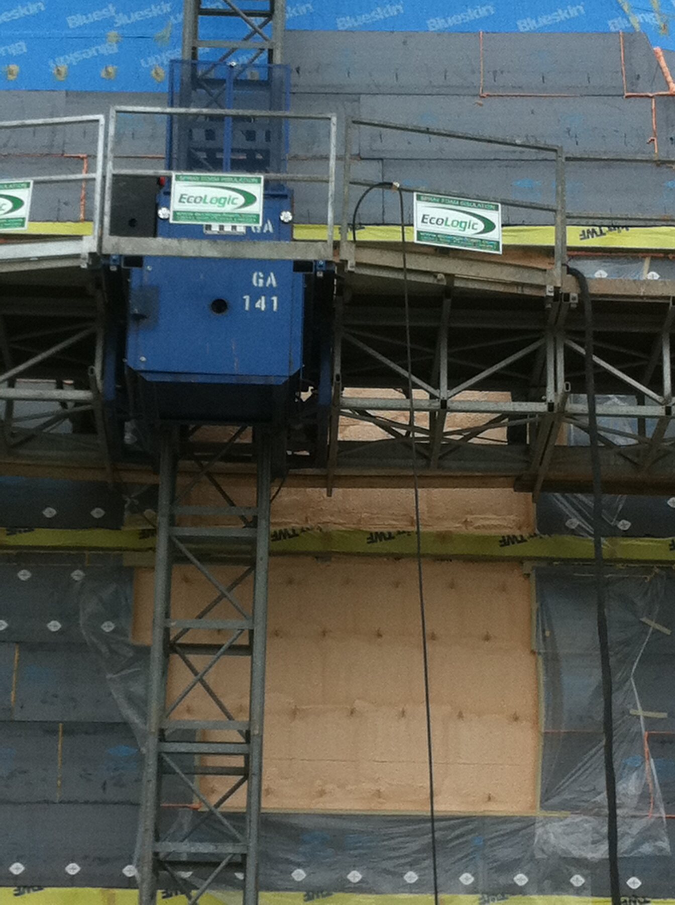 Ecologic spray foam insulation signage mounted on the construction hoist platform at the museum site
