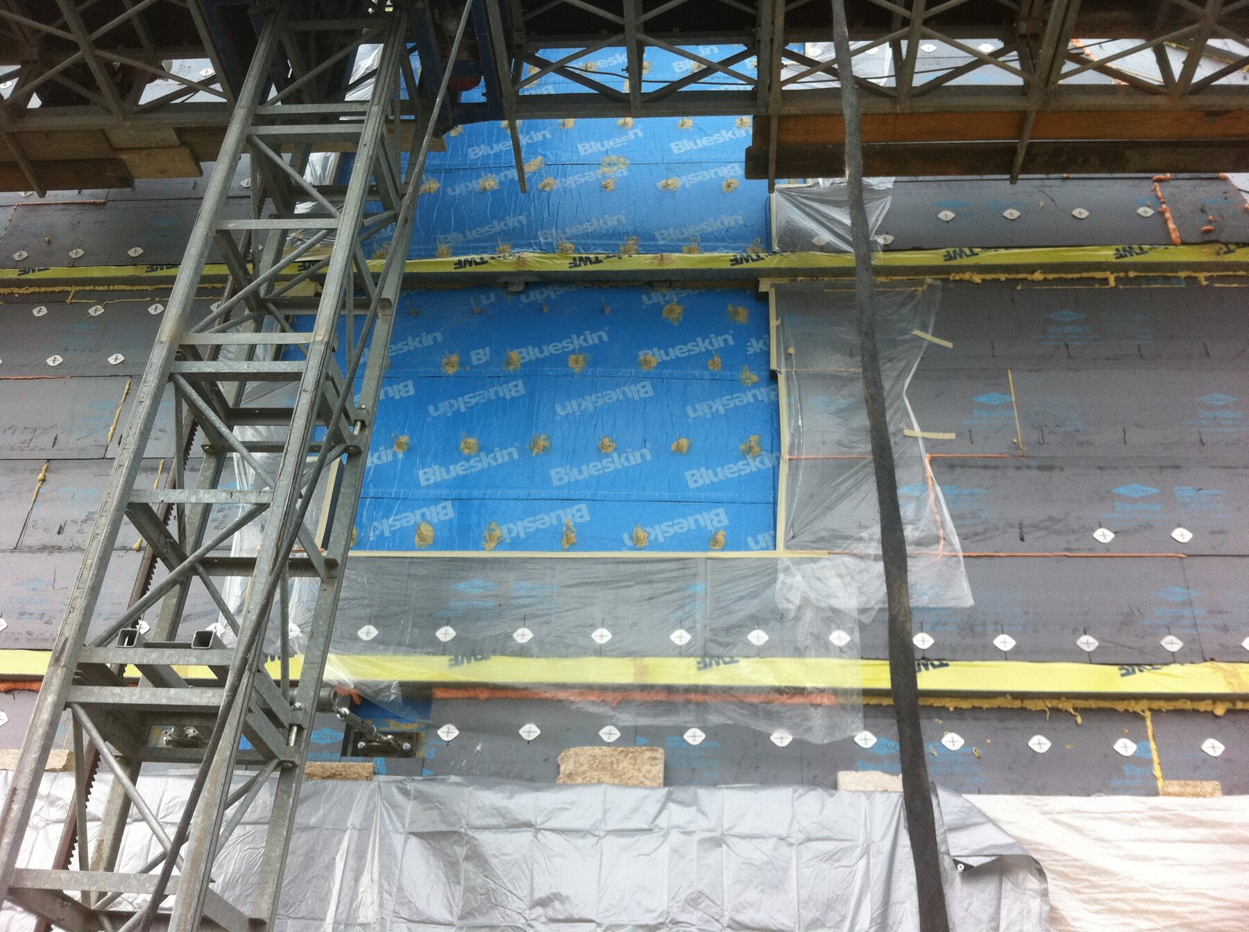 Wide view of the museum's Blueskin-wrapped wall assembly from the scaffold, showing the scale of the enclosure work