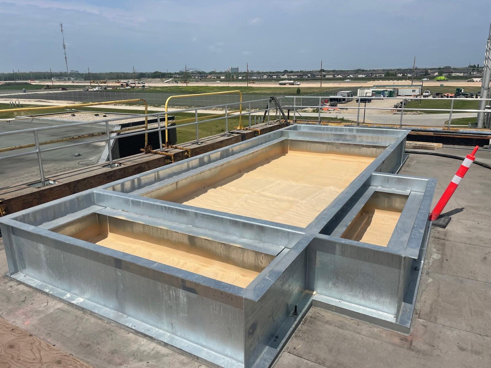 Rooftop steel process tanks at a commercial water treatment plant insulated with spray foam